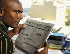 black_man_reads_paper.jpg
