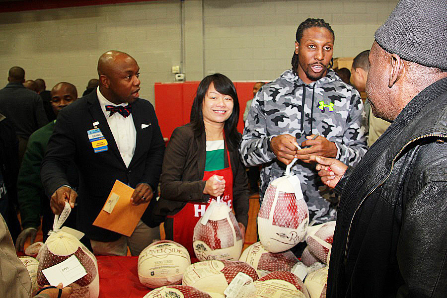 Quincy Springs of Walmart, left, Amy Phuong of the Parks and Recs, center, and Roddy White all hand out turkeys. 