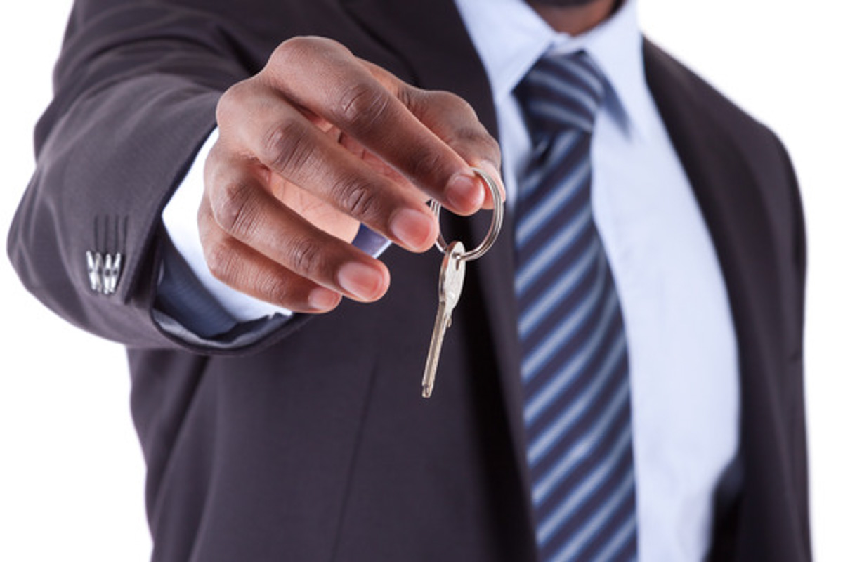Young African American businessman holding a house key