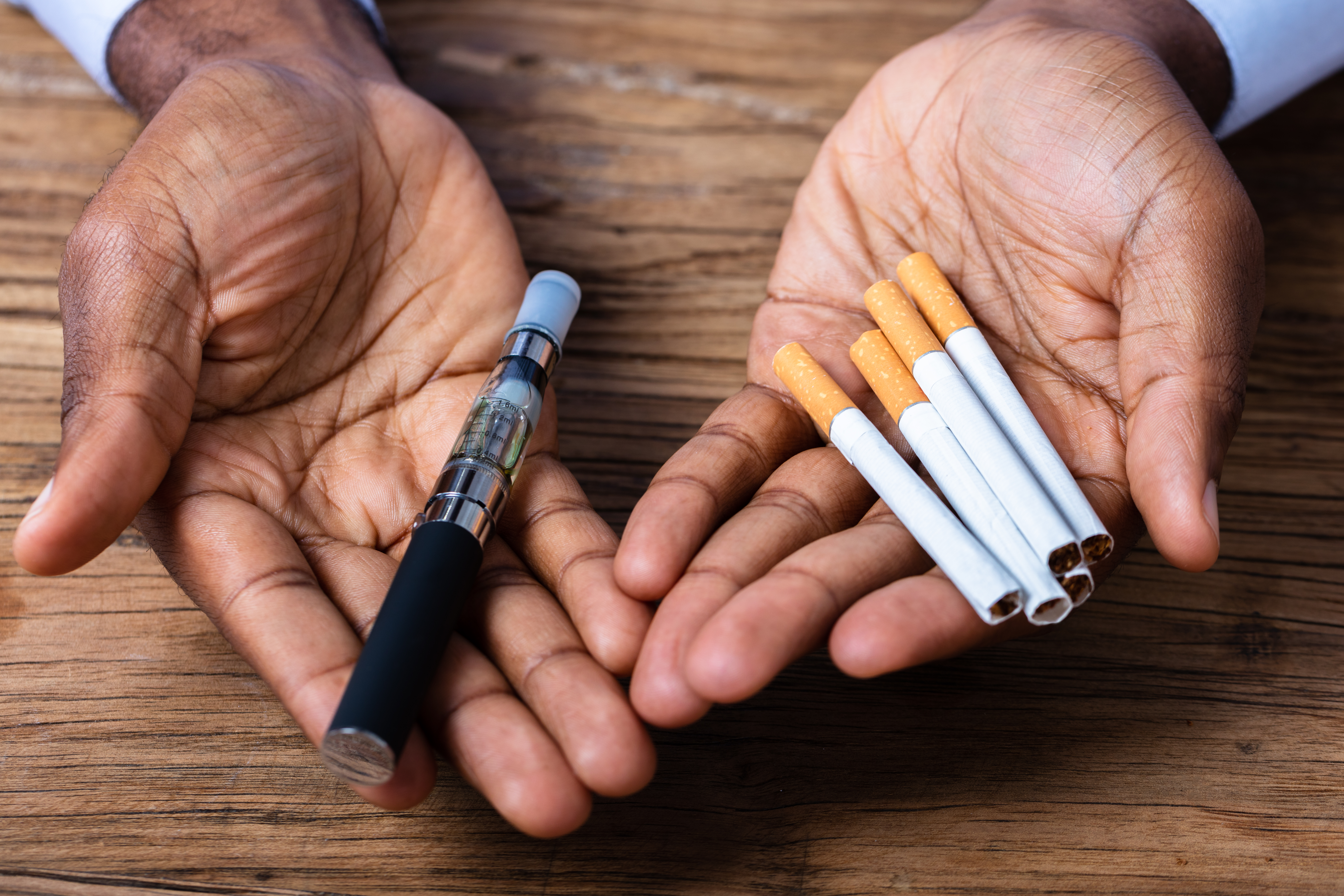 Man Holding Vape And Tobacco Cigarettes