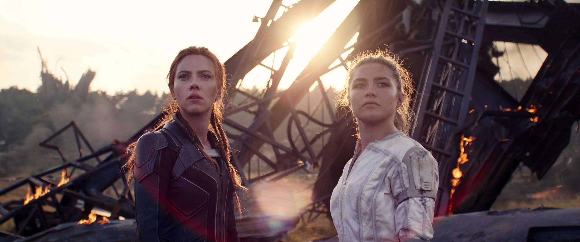 Black Widow and Yelena Belova stand at the wreckage of ship in the sand
